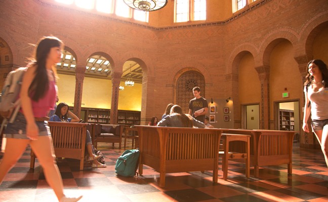 Students study and walk through the Powell Library rotunda.