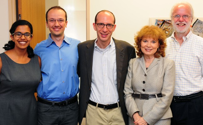 Three female and two male faculty members at an event