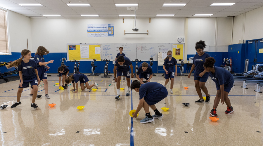 Students in indoor gym practicing agility drills.