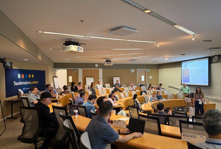 UCLA Anderson alumni seated in a tiered classroom attending a faculty-led lifelong learning session, with a Transformative Leaders banner visible on the wall.