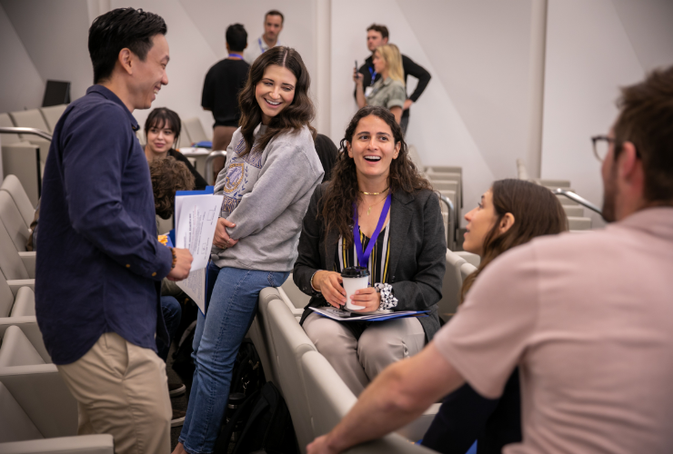 UCLA Anderson students laughing and engaging in conversation in a classroom setting.