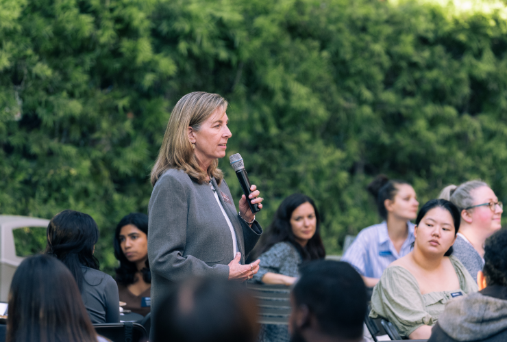UCLA Anderson faculty member presenting at a social impact event to an engaged audience.