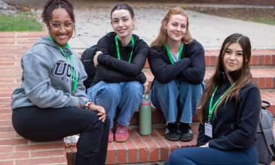 A group of students sitting on brick stairs.