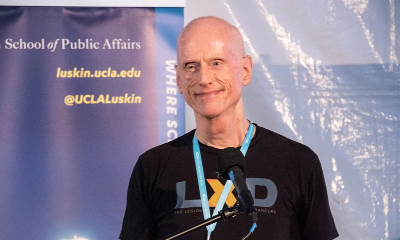 Maciek Kolodziejczak standing in front of a sign.