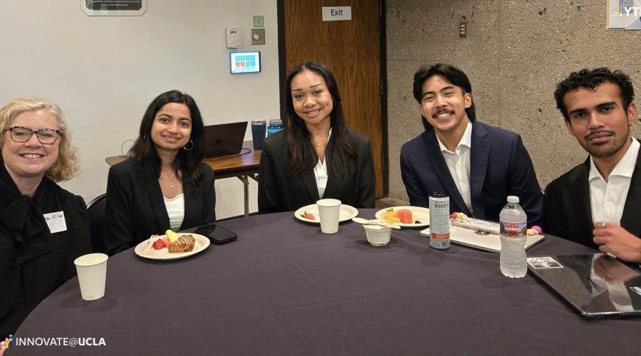 Students and faculty members sitting at a table.